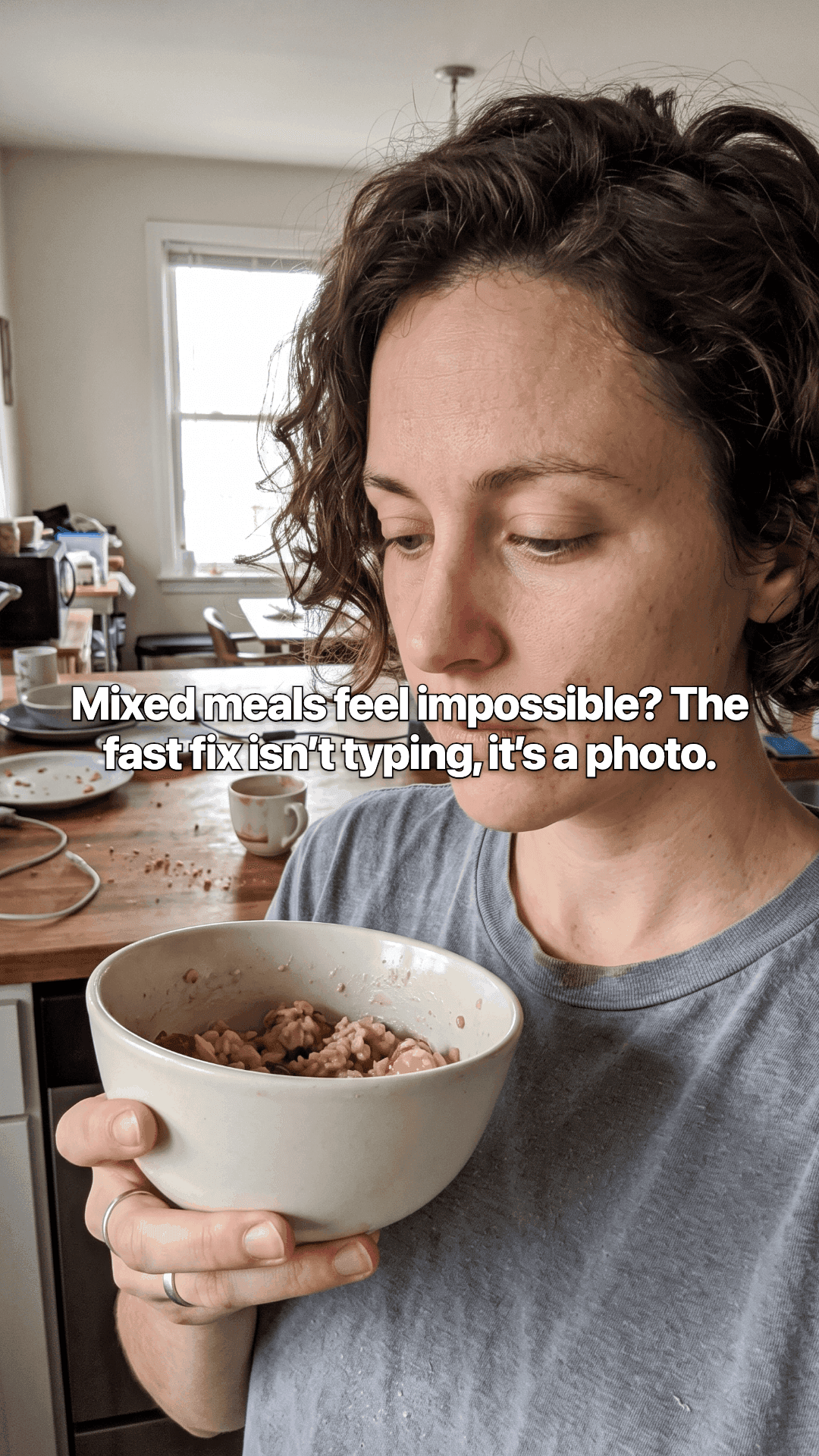 A woman in a kitchen holding a bowl of oatmeal, looking down at it, with the opening line of the post across the photo.